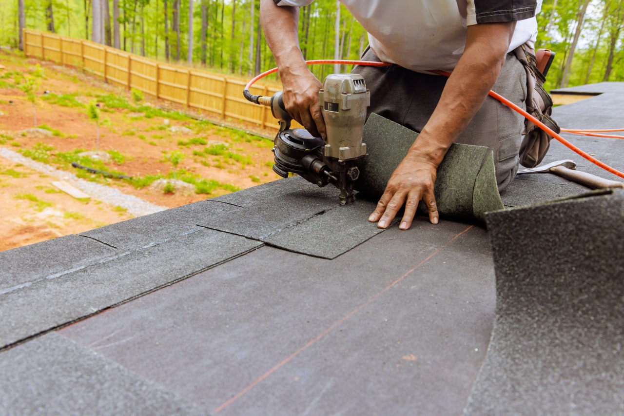 Roofer installing asphalt shingles on a residential roof